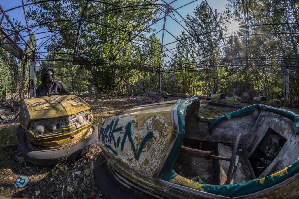 two wrecked white and yellow bump cars surrounded with trees