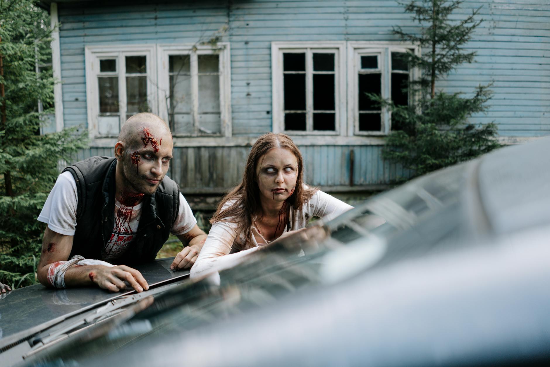 two zombies leaning on a car